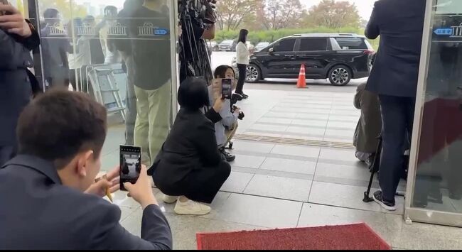 최민희 더불어민주당 의원이 15일 낮 하이브 및 어도어 걸그룹 뉴진스 멤버 '하니'의 국회 환경노동위원회(환노위) 출석 때 넋을 잃고 휴대폰으로 사진을 찍고 있다. (사진=이기인 최고위원 페이스북 캡쳐)