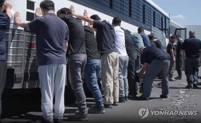 양손과 다리에 체인 묶는 단속요원들