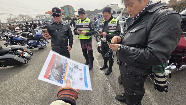 할리데이비슨 행사장에서 싱크홀 사건 보험료 지급 촉구 전단지를 나눠주고 있는 이실협 전창욱 협회장(사진=이실협 제공)