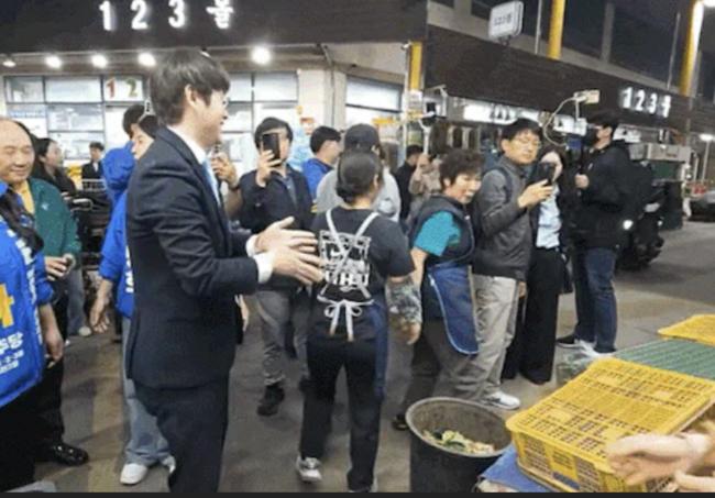 구포시장을 방문해 상인과 악수를 한 후 손을 털고 있는 하정우 전 AI수석(커뮤니티 갈무리)